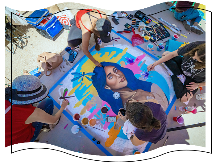 Students drawing a beatiful woman on the sidewalk with chalk