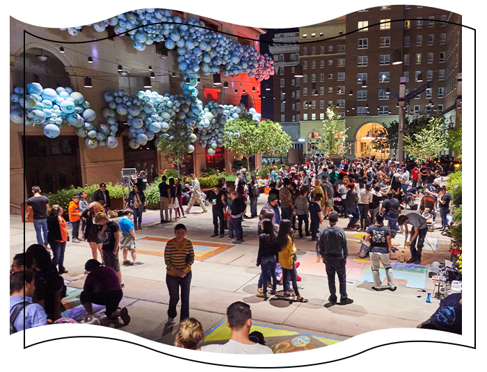 People standing and drawing at chalk the block