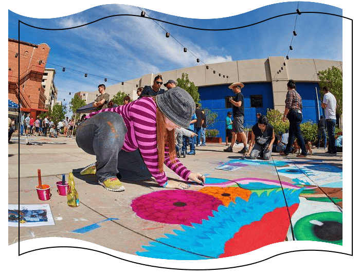 Girl drawing a bird on the sidewalk.